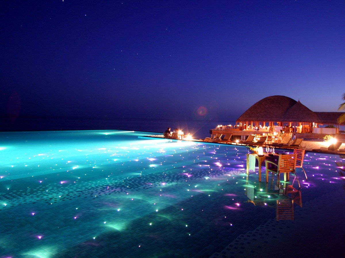 maldives-resort-huvafen-fushi-is-set-up-for-gorgeous-evening-swims-with-colored-lights-twinkling-beneath-the-surface