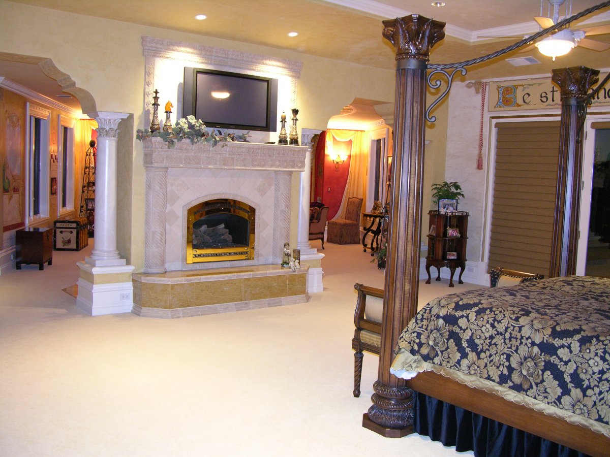 the-master-bedroom-has-a-large-fireplace-right-in-between-two-columns