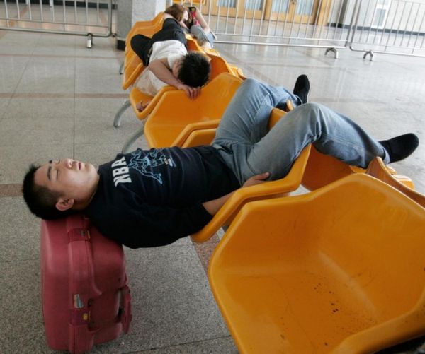 14173360-R3L8T8D-650-80348-a-traveller-sleeps-while-waiting-for-his-train-at-the-beijing-railway-_result